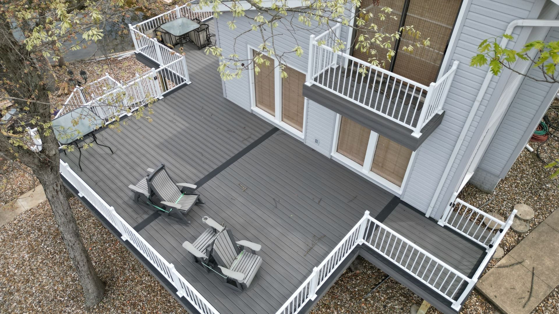 Aerial view of a multi-level gray wooden deck with white railings