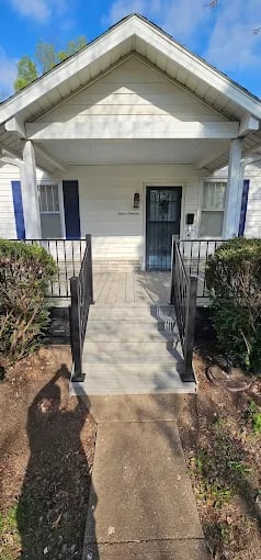 White house with blue trim and wheelchair ramp leading to front entrance