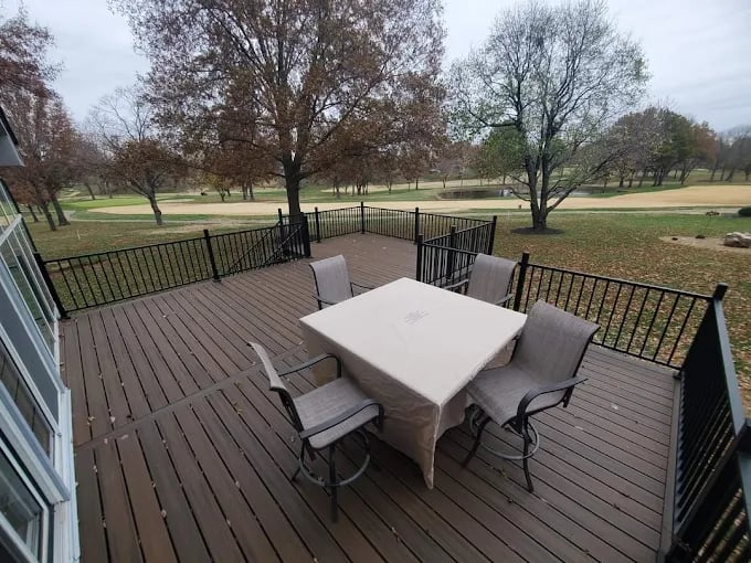Wooden deck with table and chairs overlooking a peaceful park landscape