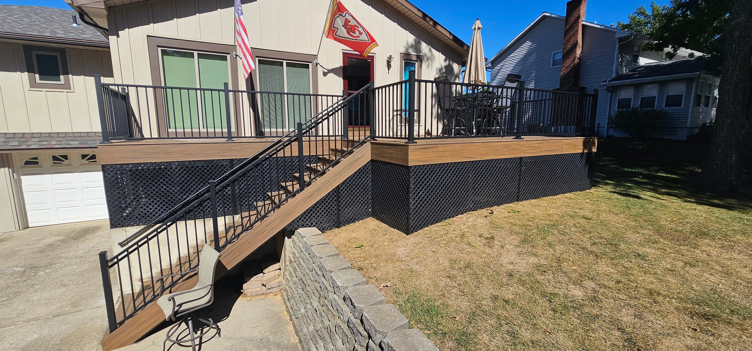 Wooden deck with stairs, metal railings, and Kansas City Chiefs flag
