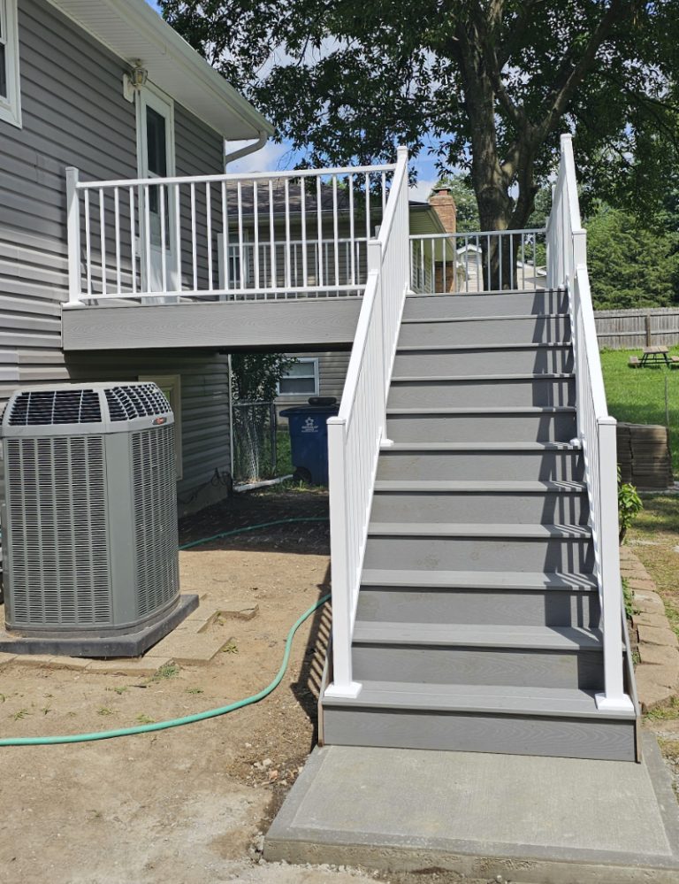 White wooden stairs leading to an elevated deck with white railings