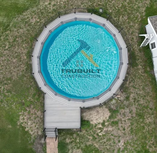 Aerial view of circular blue swimming pool with construction logo